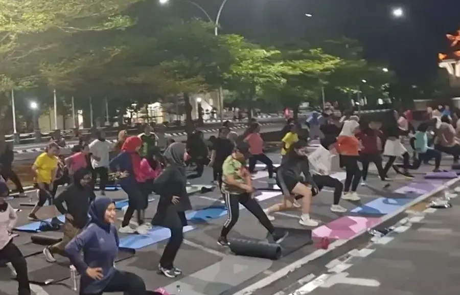 Peserta berlatih bersama di ruang terbuka pada malam hari
